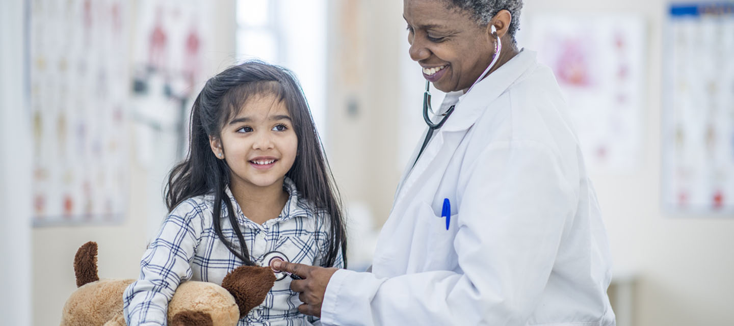 physician listening to child's heart with a stethoscope