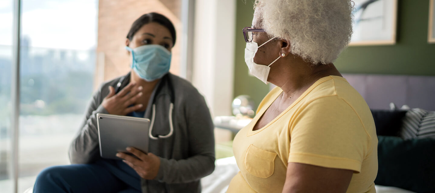 nurse and patient having a discussion while wearing protective masks