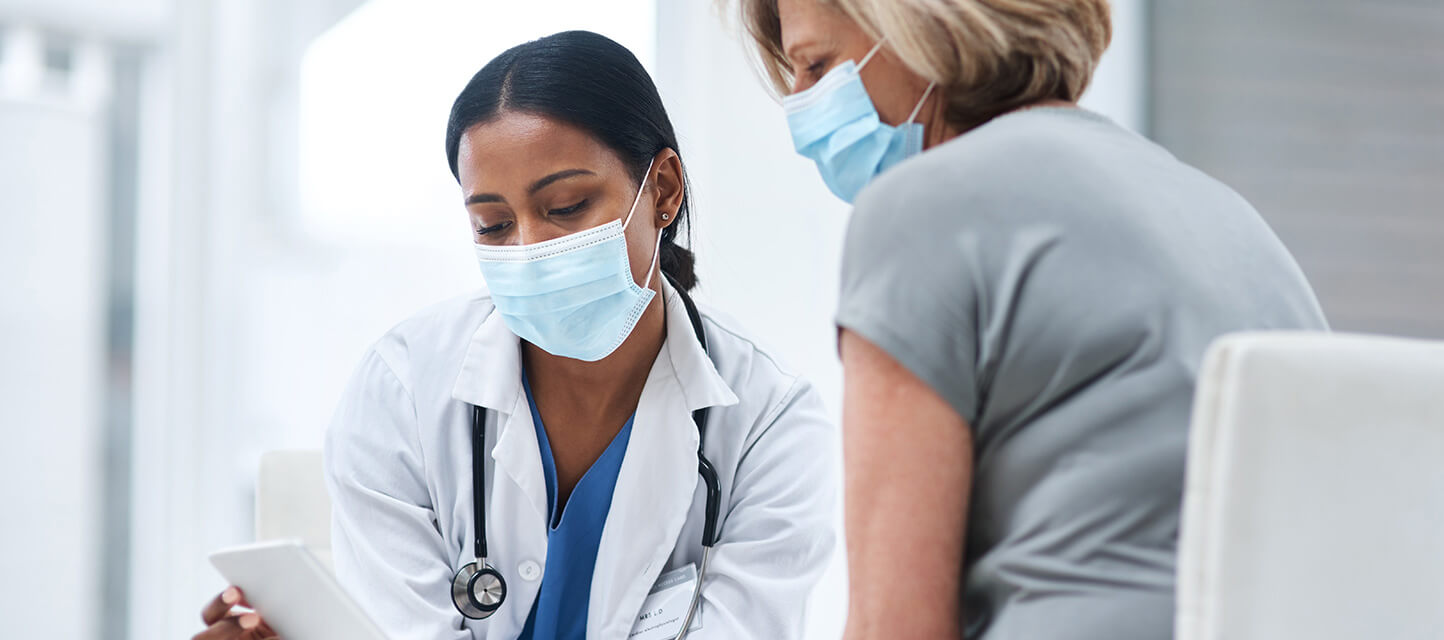 patient and physician talking and wearing protective masks