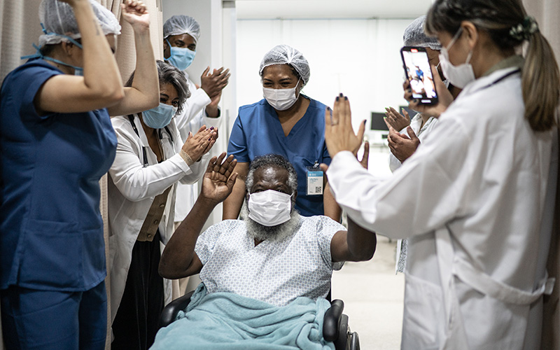 Celebrating senior man leaving hospital after recovery