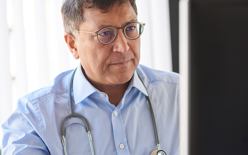 Doctor using the computer and wearing a stethoscope