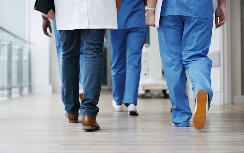 Group of hospital staff walking through hallway
