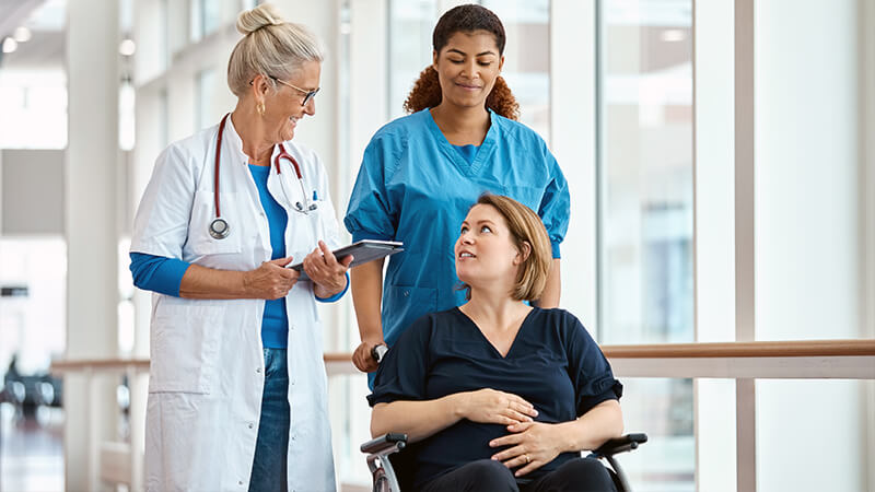 Doctor and nurse helping pregnant patient