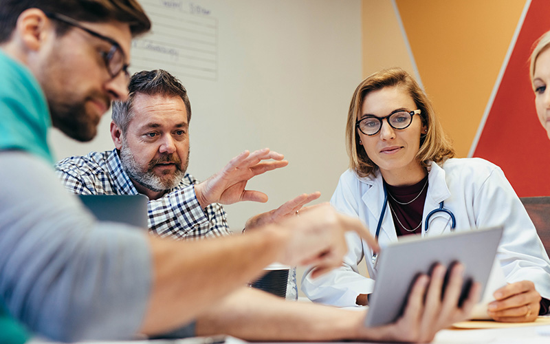 Medical staff using tablet in meeting