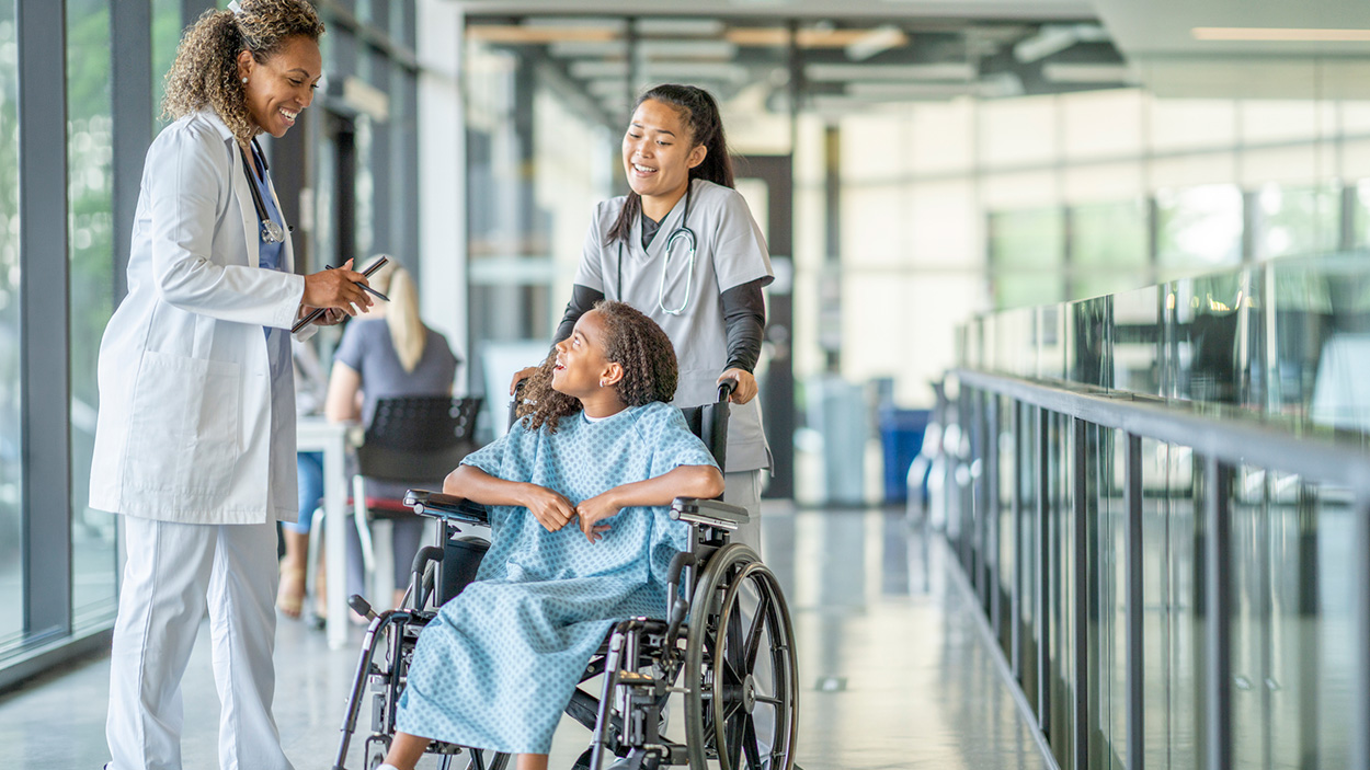 Clinician speaking with child in a wheelchair