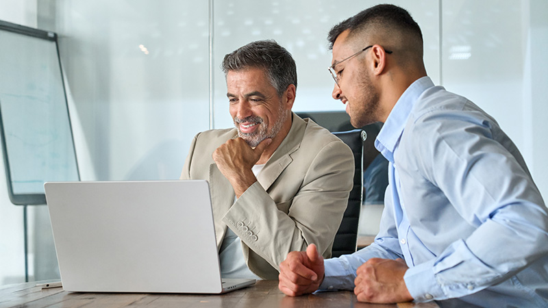 Two businessmen having discussion in front of laptop