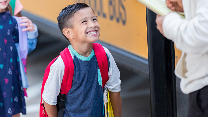 Young child checking in with teacher