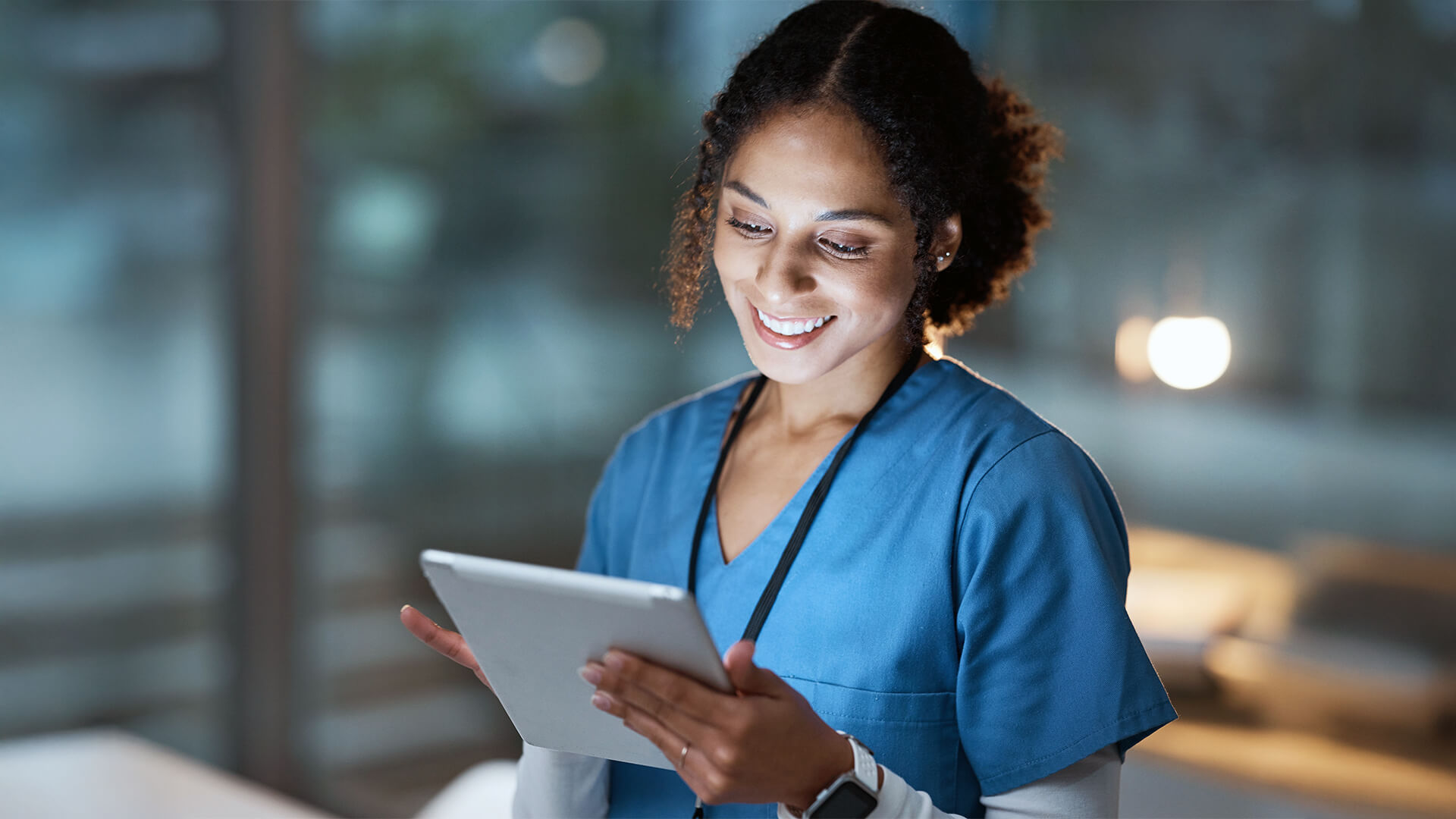 Female nurse using her digital tablet while standing in the consultation