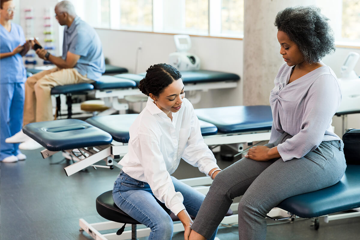 Patient having knee examined by physical therapist