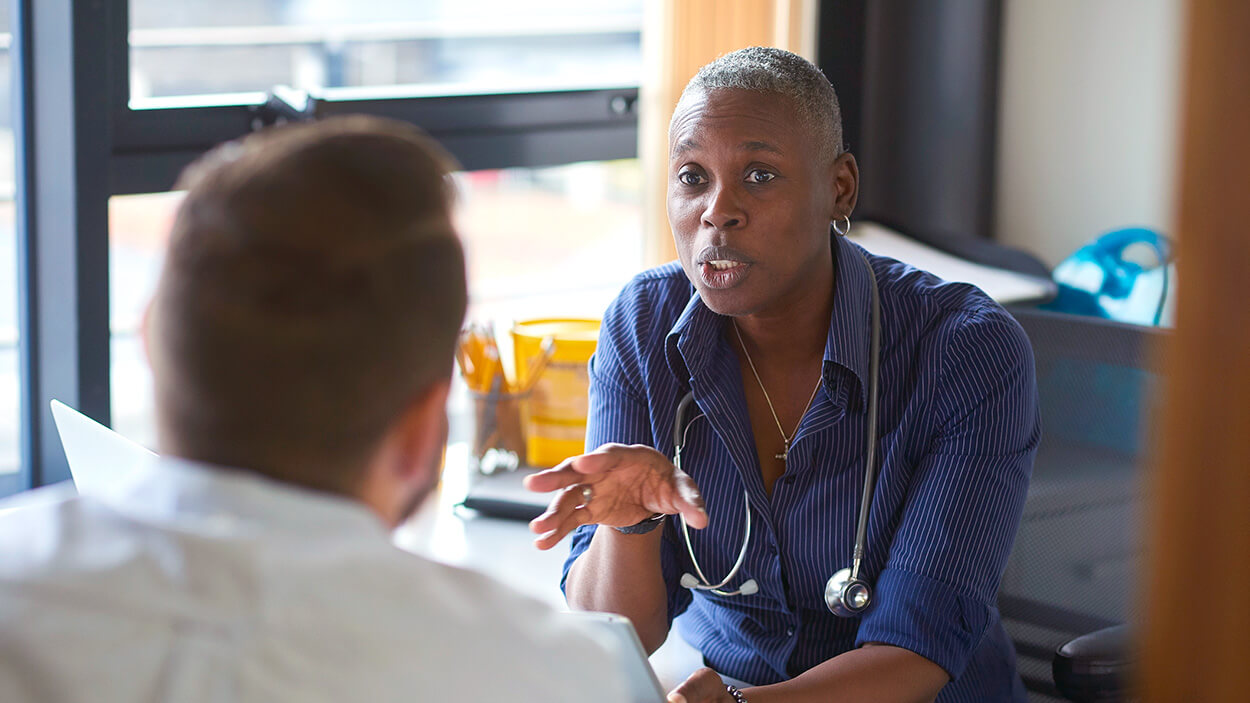 Doctor discussing care plan on tablet with patient