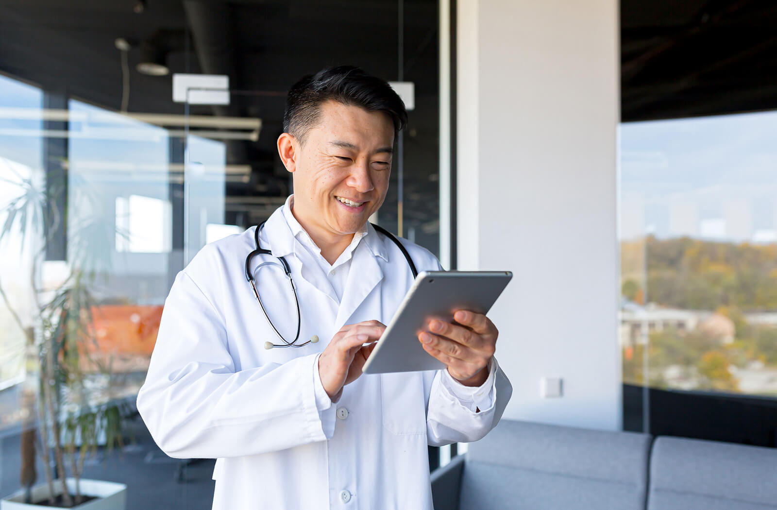 Cheerful doctor using tablet