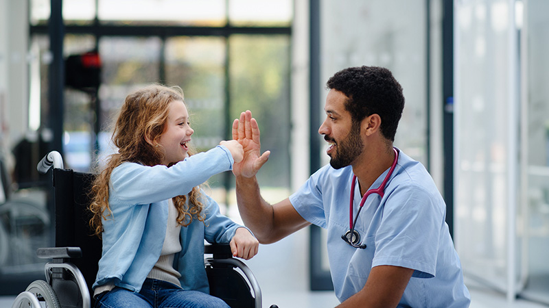 Child patient high fiving with clinician