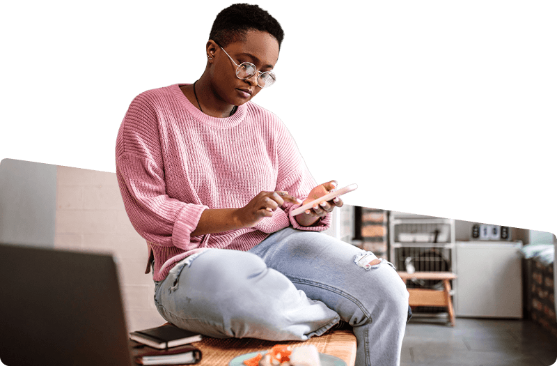 Young woman of color checking her phone at home