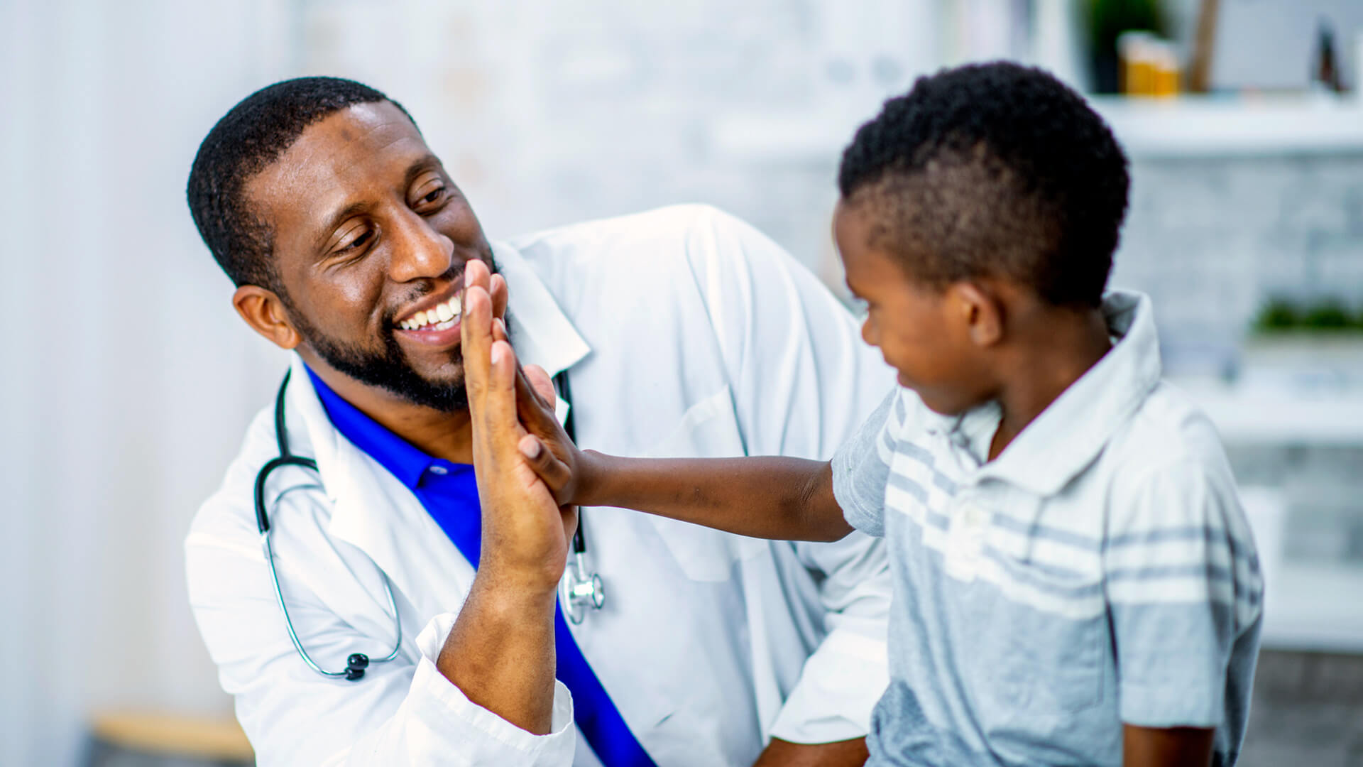 Physician high fiving child patient