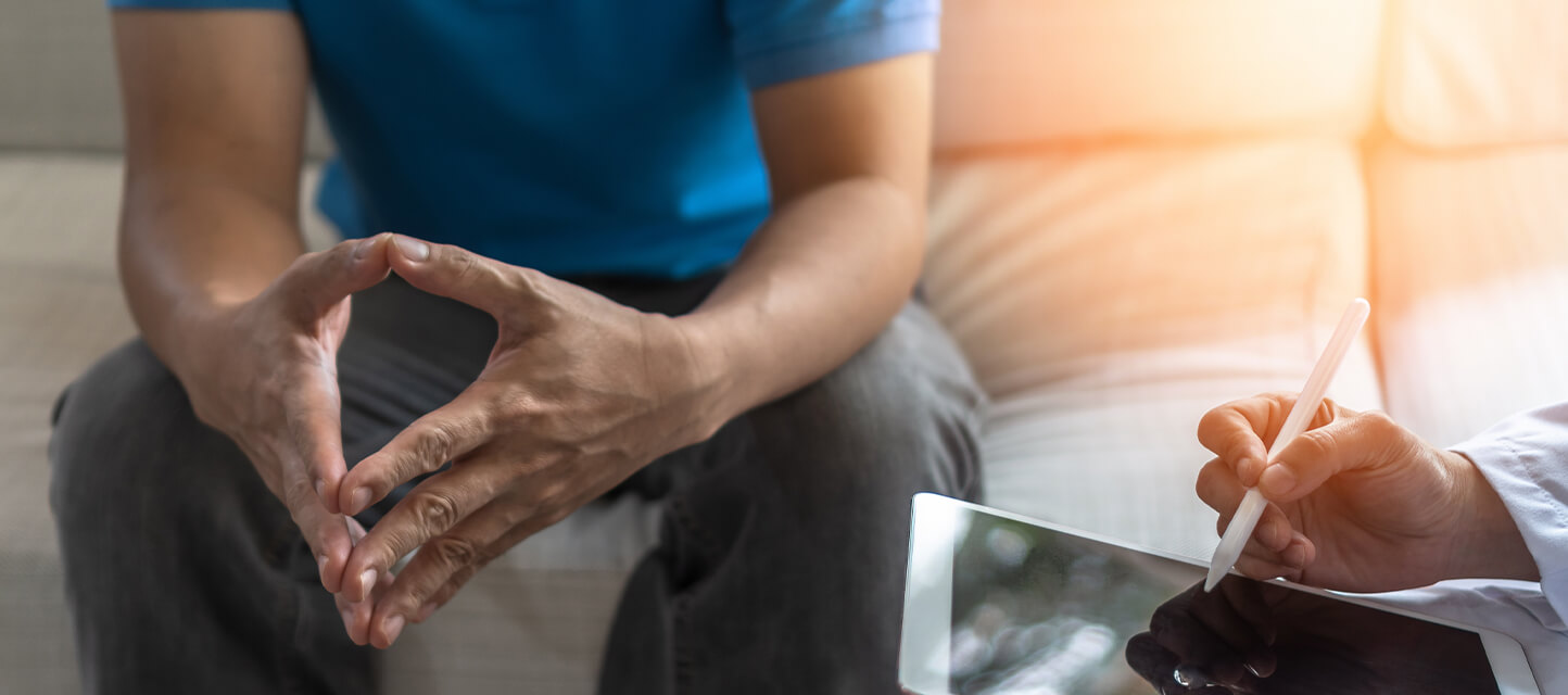 Doctor speaking with patient while using tablet