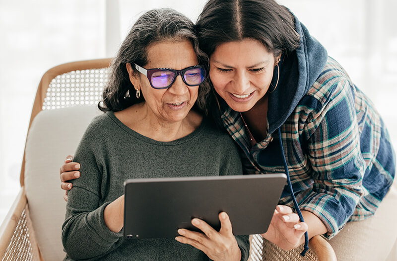 elderly parent with their child using tablet