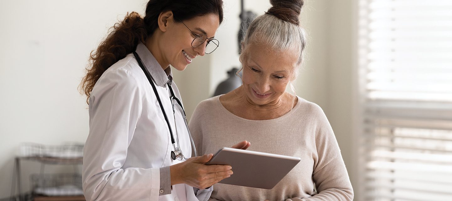 a female dr pointing out information to a female patient on a tablet
