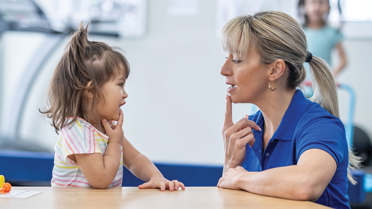 female speech therapist working with young girl