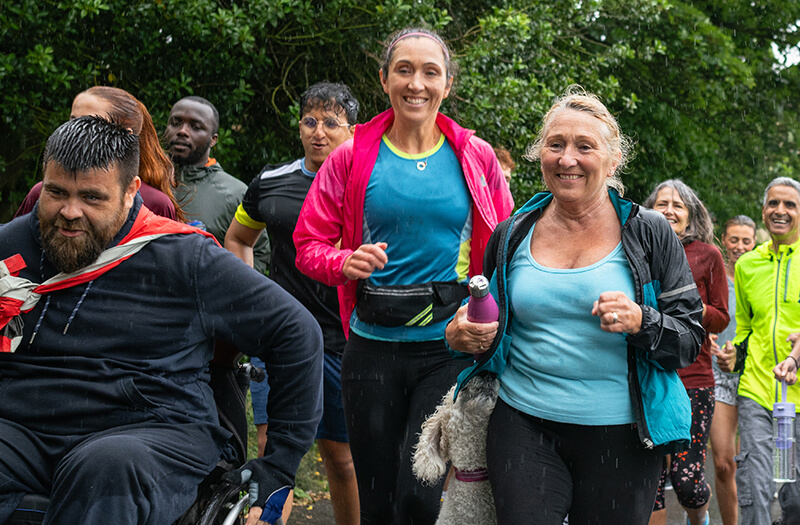 A group of people running together in the rain