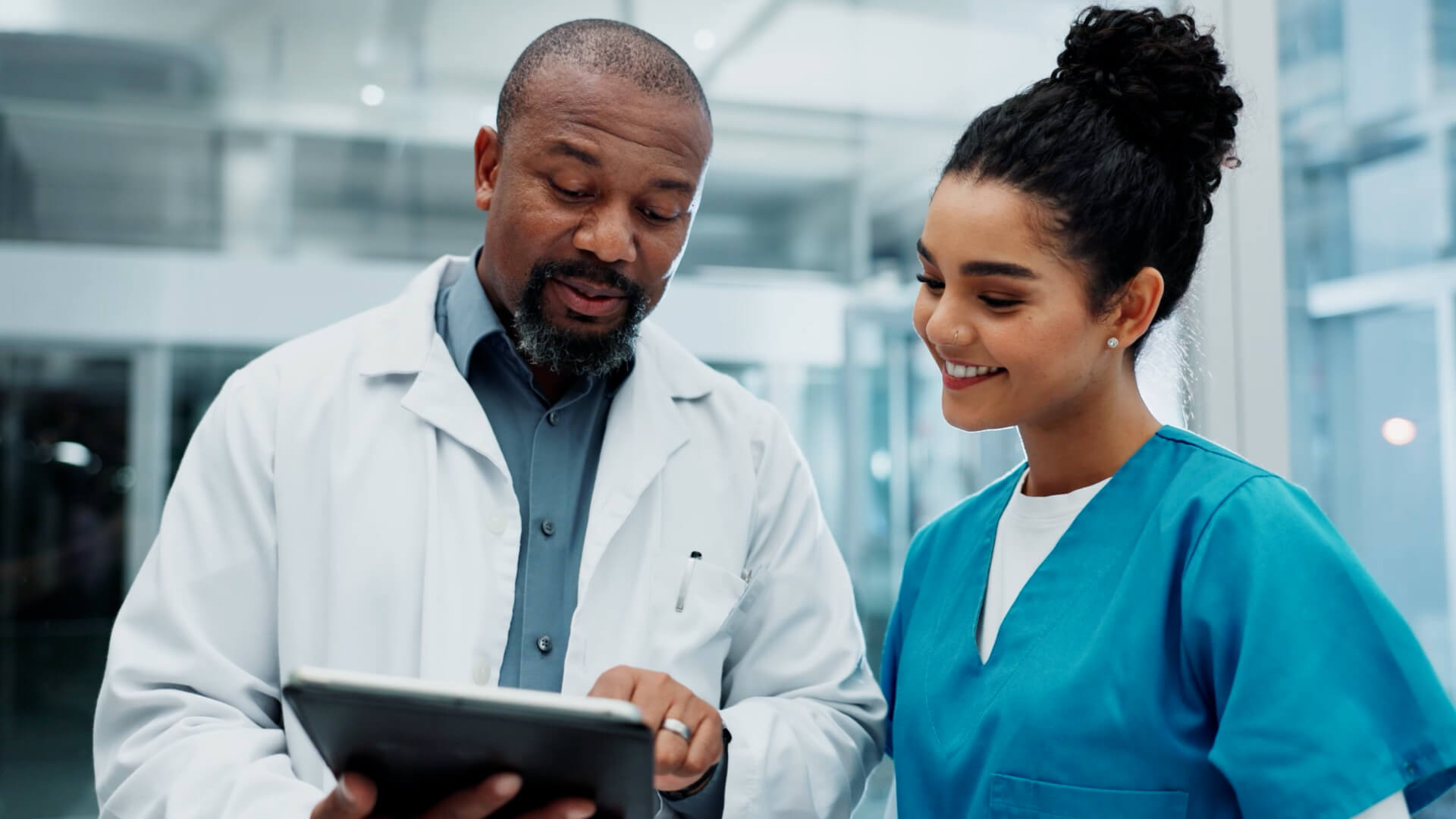Two physicians collaborating and using an iPad in a clinical setting