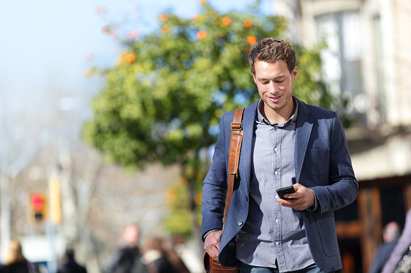 Man walking down the street looking at his phone