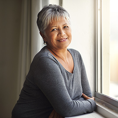 Patricia's head shot - middle aged woman leaning on windowsill