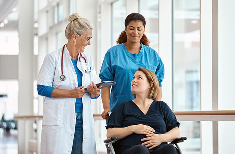 Older Docter having a discussion with a pregnant patient while they're in transport