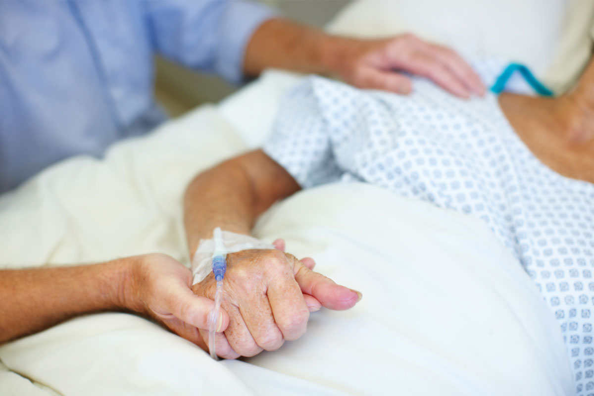 elderly patient in a hospital bed with an IV