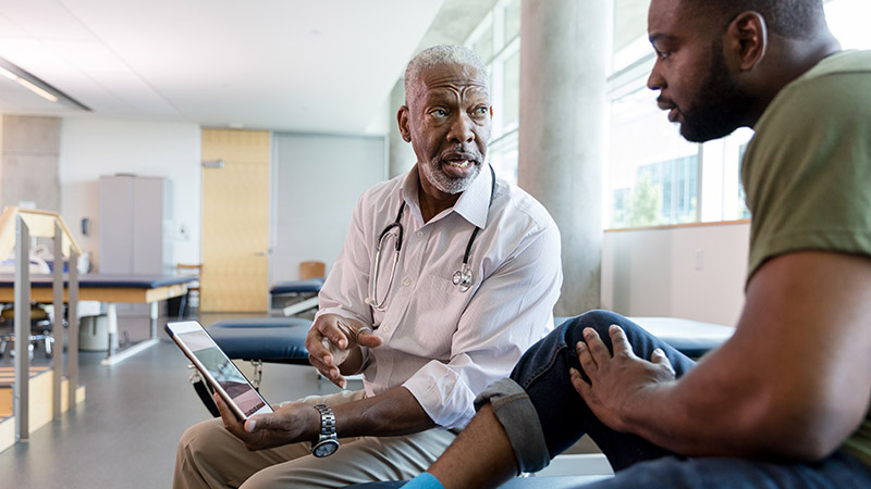 physical therapist shows patient data on tablet