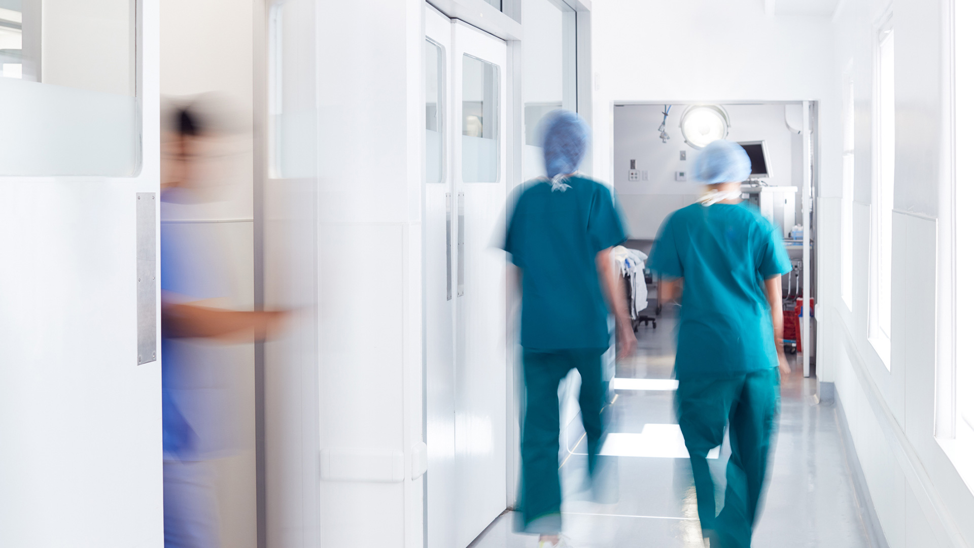 Two surgeons walking down hallway in critical care unit