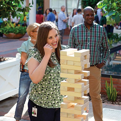 MEDITECH staff memebers laughing playing giant jenga at an event