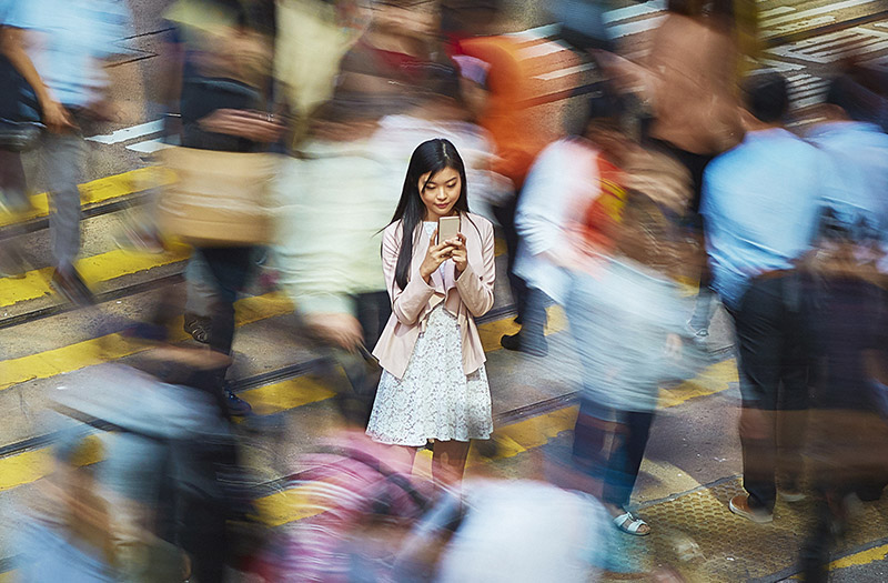 woman on phone among street crowd